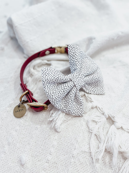 Black and white dots, over the collar, dog and cat bow